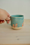 Taza Latte Coral sujeta por el asa