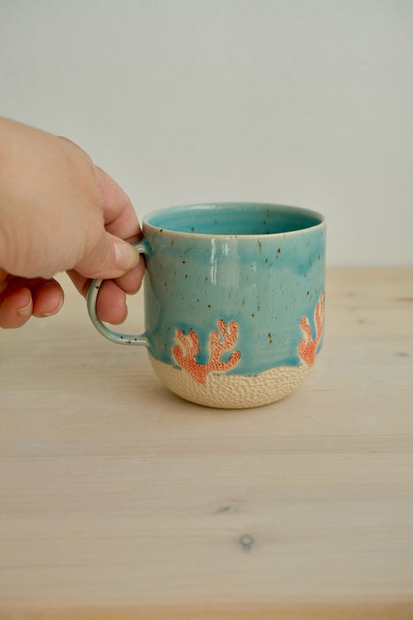 Taza Latte Coral sujeta por el asa