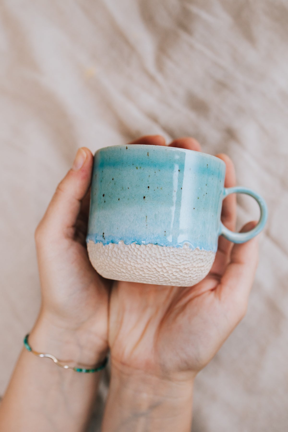 Latte Sea cup – handmade turquoise stoneware mug held in hands