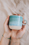 Latte Sea cup – handmade turquoise stoneware mug held in hands