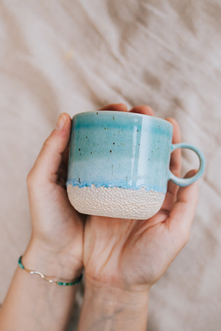 Latte Sea cup – handmade turquoise stoneware mug held in hands