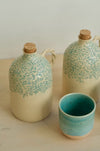 Two Pine olive oil bottles with an espresso cup