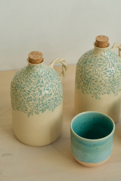 Two Pine olive oil bottles with an espresso cup